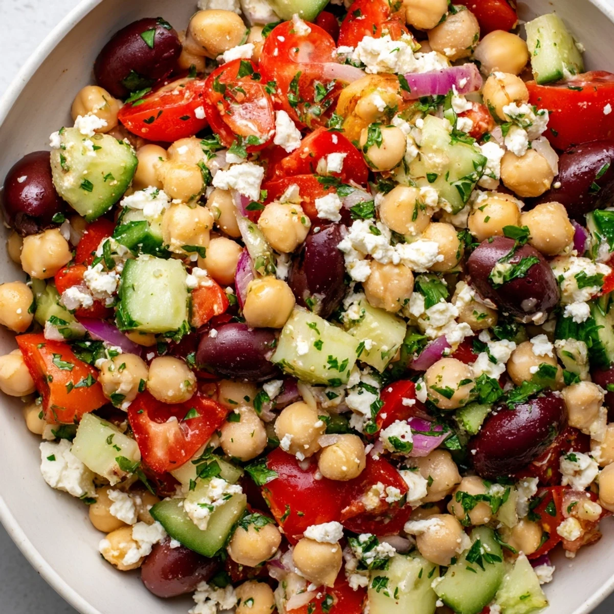 Plated Mediterranean Chickpea and Feta Salad served as a light lunch, garnished with fresh herbs and drizzled with lemon olive oil dressing.