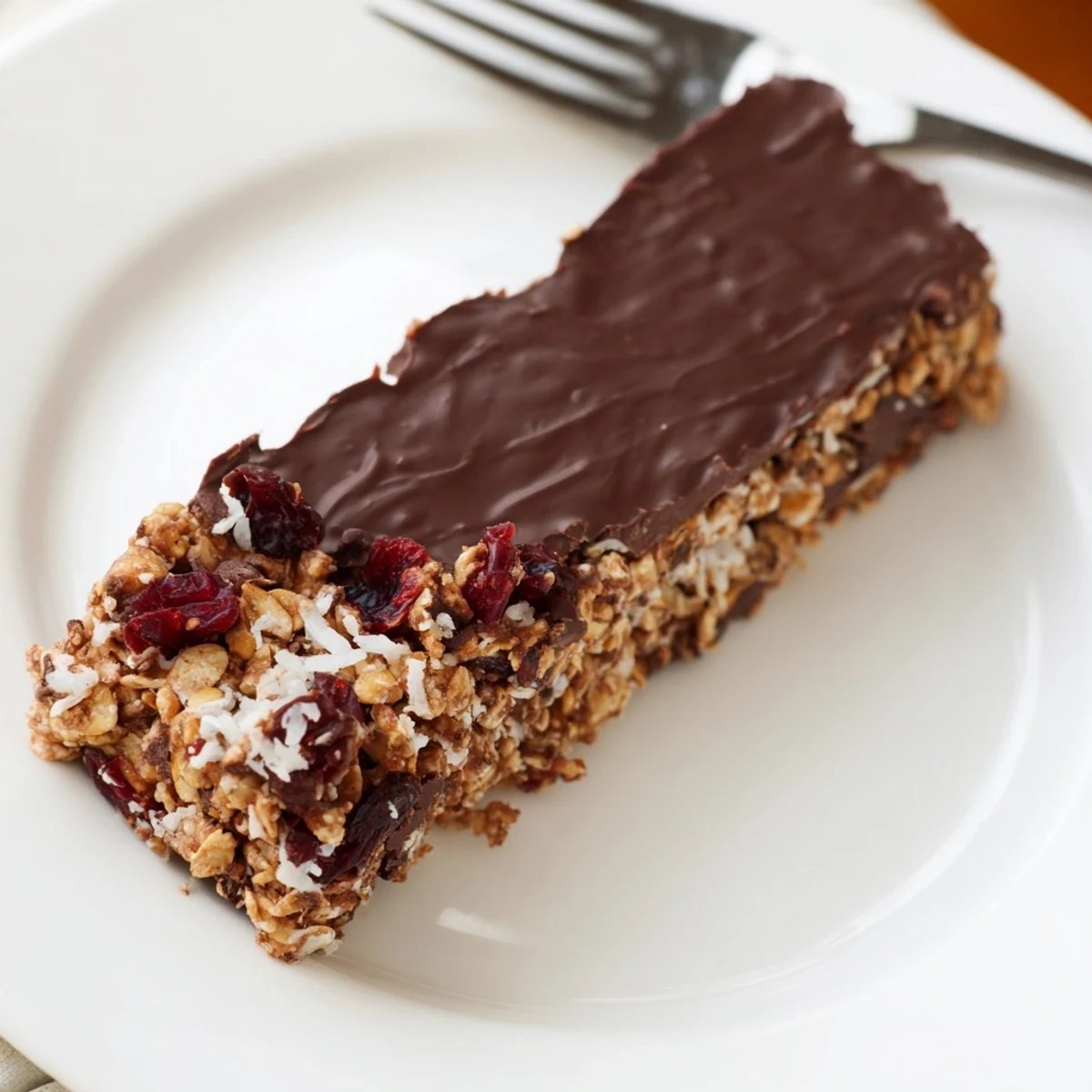 Freshly cut Chocolate Lunch Bar Snack sits on a marble board with oats, nuts, and dried fruit visible in every slice.