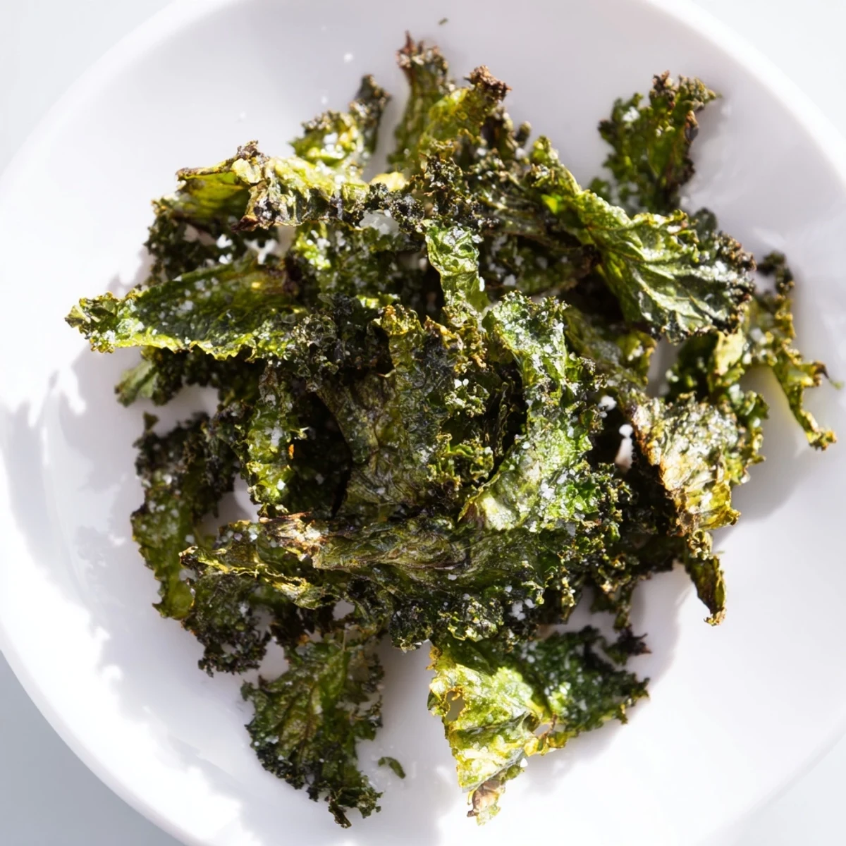 A bunch of fresh green kale leaves tossed in olive oil and sea salt, baked to a crisp texture in the oven.