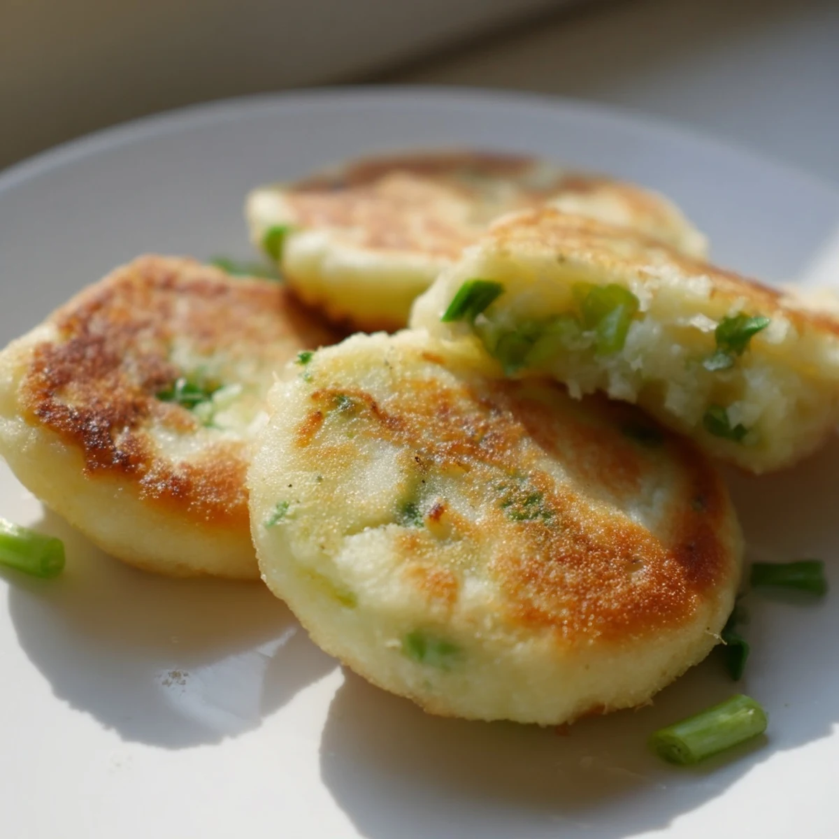 Freshly fried Irish Potato Cakes with Scallions, featuring golden, crispy edges and tender insides, served warm on a rustic plate.