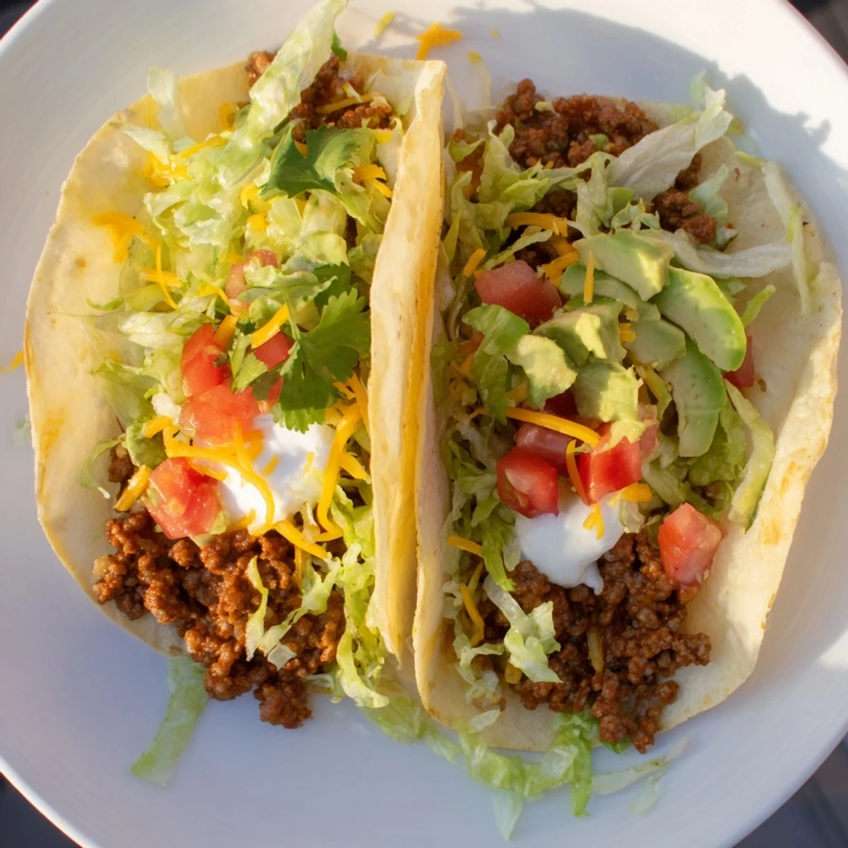 Juicy seasoned ground beef in soft tortillas, garnished with creamy avocado slices and chopped cilantro for a fresh finish.