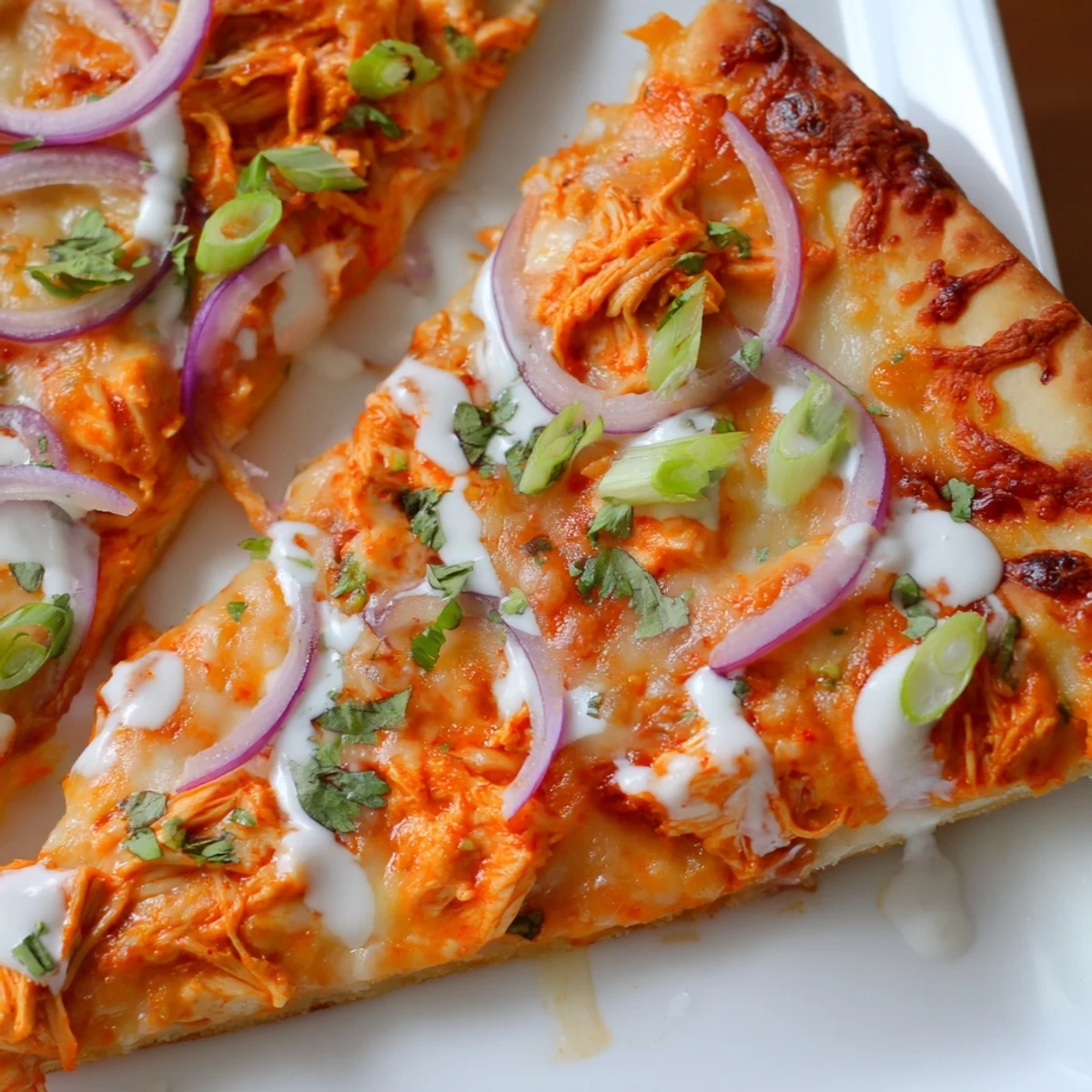 Bold Buffalo Chicken Pizza fresh from the oven, featuring a golden crust, spicy buffalo chicken, creamy ranch, and vibrant red onion slices.