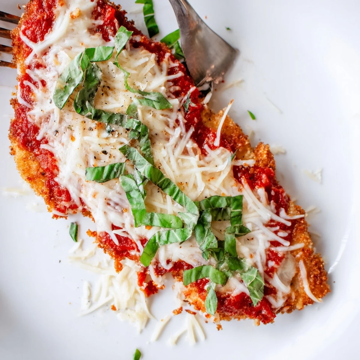 Tender golden-brown chicken breasts topped with melted mozzarella and a rich low-carb tomato sauce for this Amazing 15 Minute Keto Chicken Parmesan.