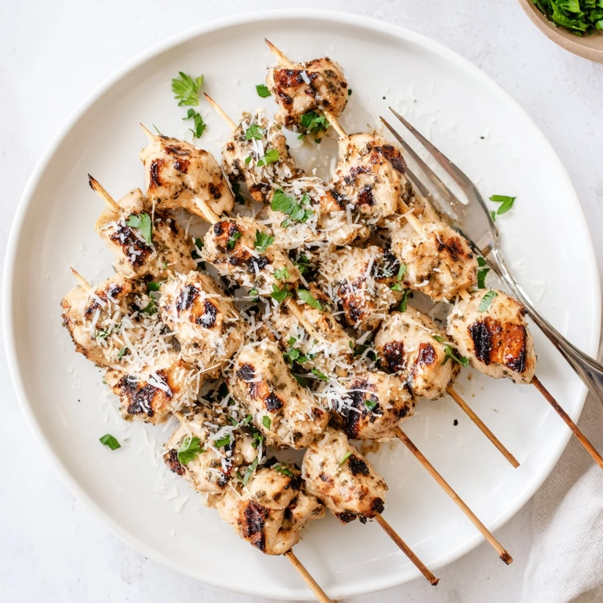 Juicy Ranch Garlic Parmesan Chicken Skewers on a wooden platter garnished with fresh green parsley