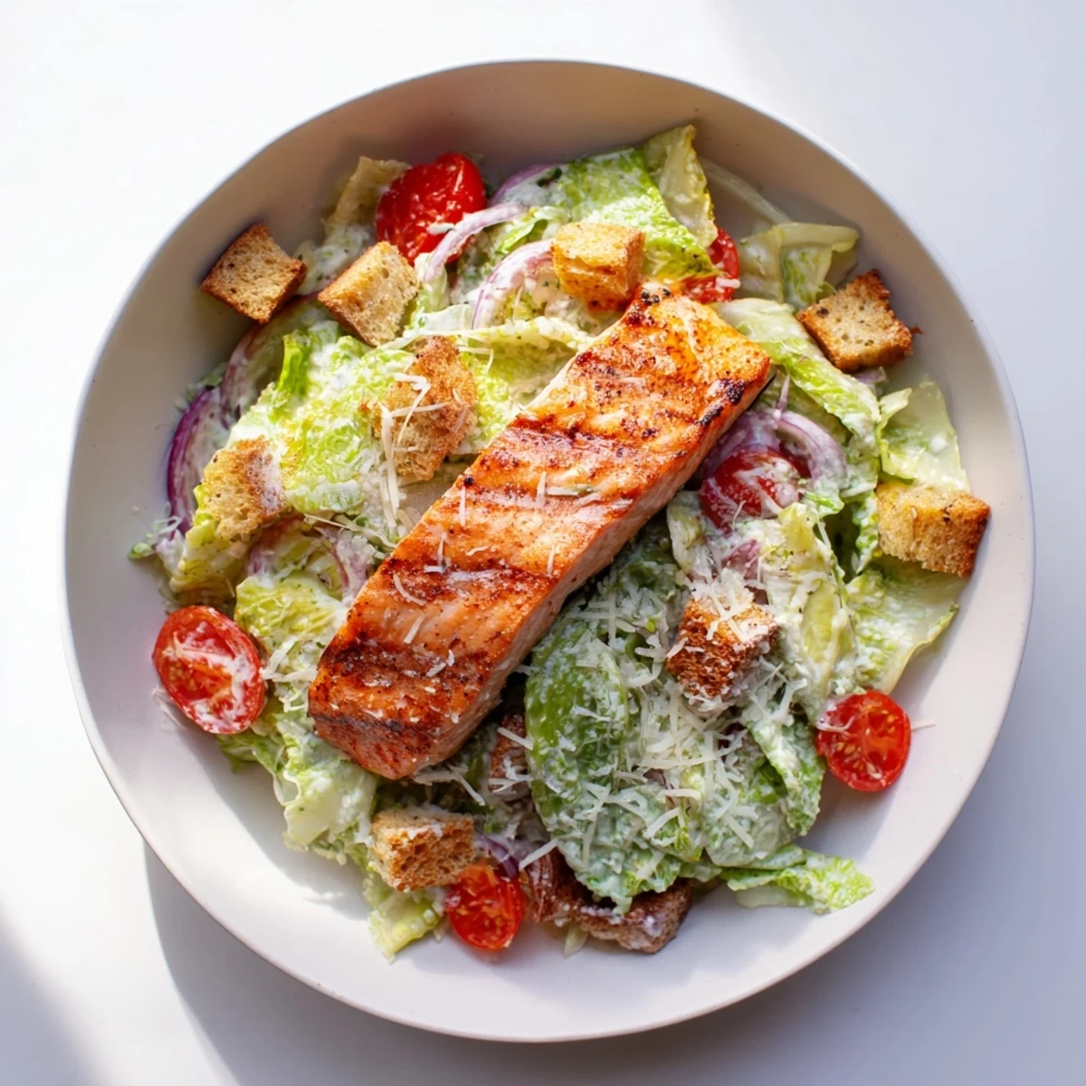 Vibrant salmon Caesar salad plate featuring flaky grilled fish crunchy croutons and creamy homemade dressing