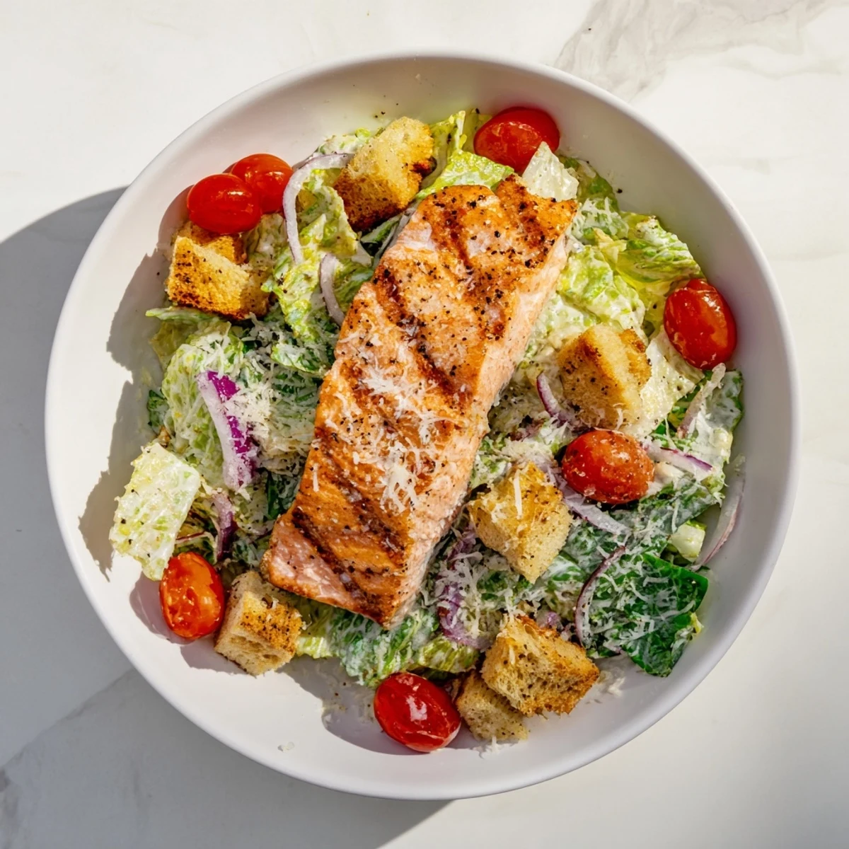 Succulent seasoned salmon atop chopped romaine lettuce with red onion Parmesan and tangy Caesar dressing