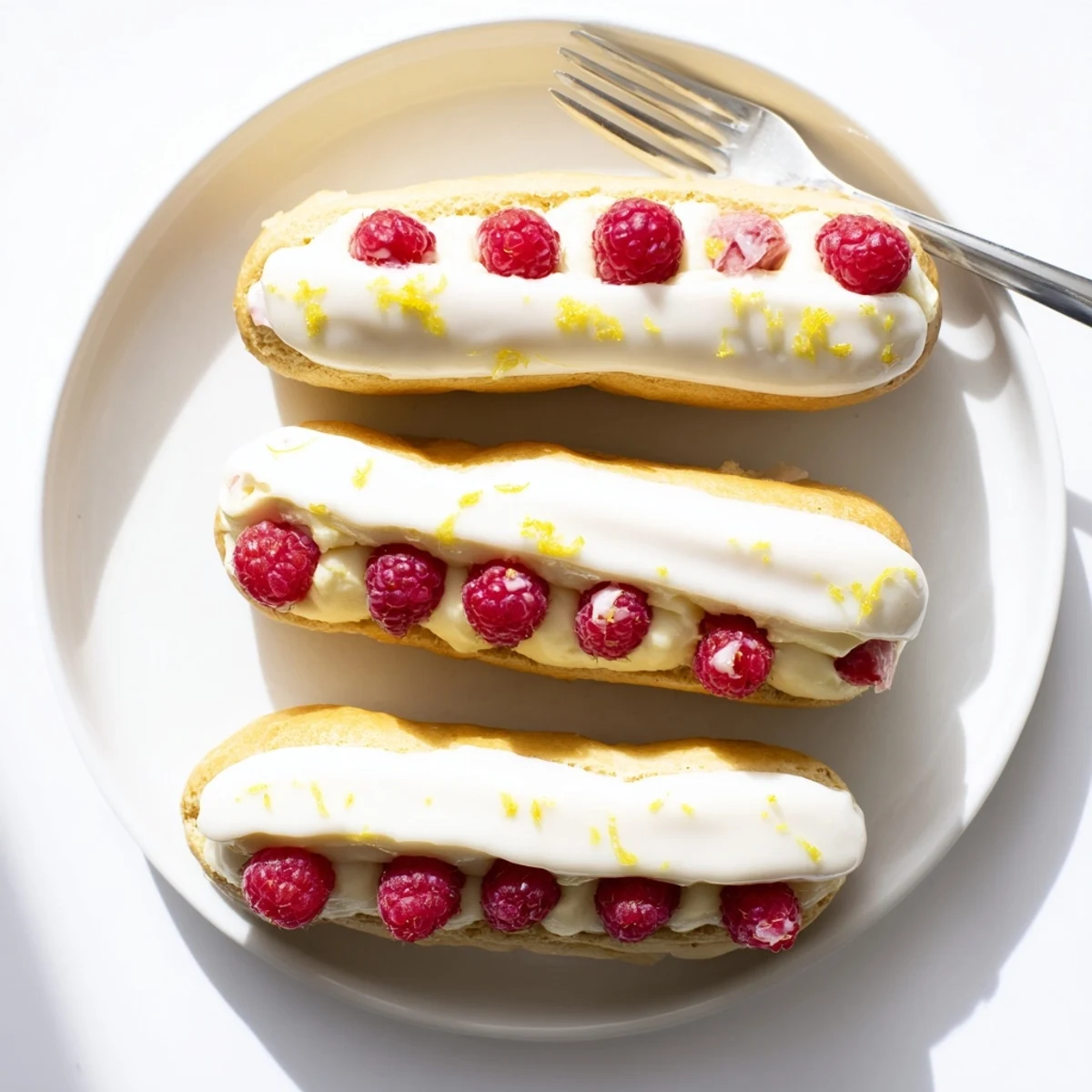 Elegant lemon raspberry dessert with smooth cream filling and delicate powdered sugar glaze