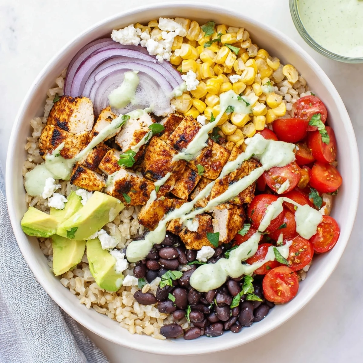 Hearty protein packed street corn chicken bowl featuring juicy spiced chicken, sweet corn with cotija, fresh veggies, and creamy lime dressing.