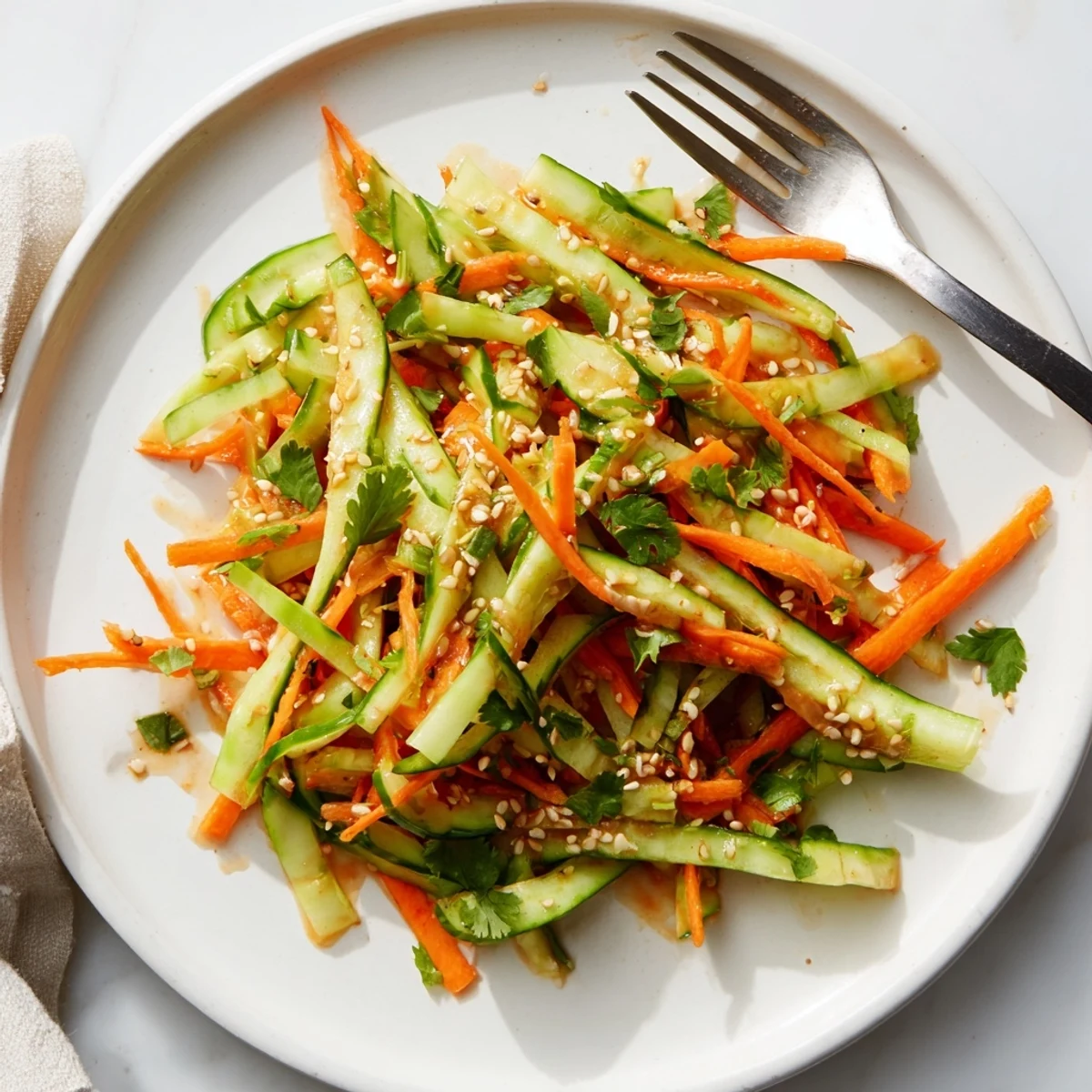 Close-up of refreshing Asian cucumber salad featuring thin cucumber slices tossed in savory soy sesame dressing