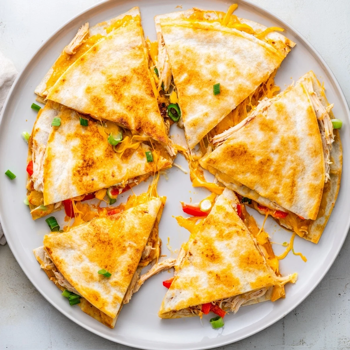 Crispy oven-baked quesadillas stuffed with seasoned shredded chicken and gooey Mexican cheese blend
