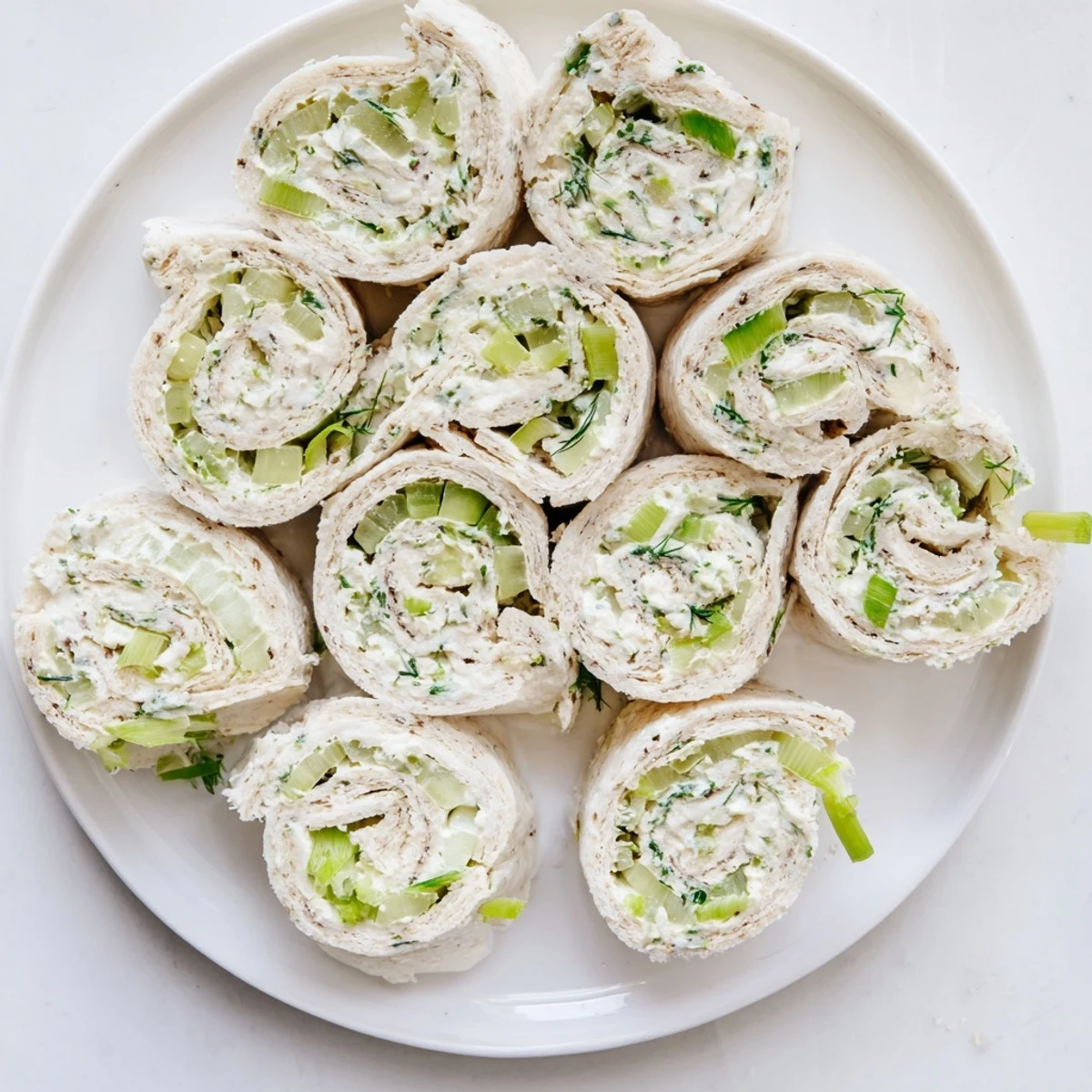 Creamy pickle and cream cheese pinwheel slices featuring green onion and dill swirls