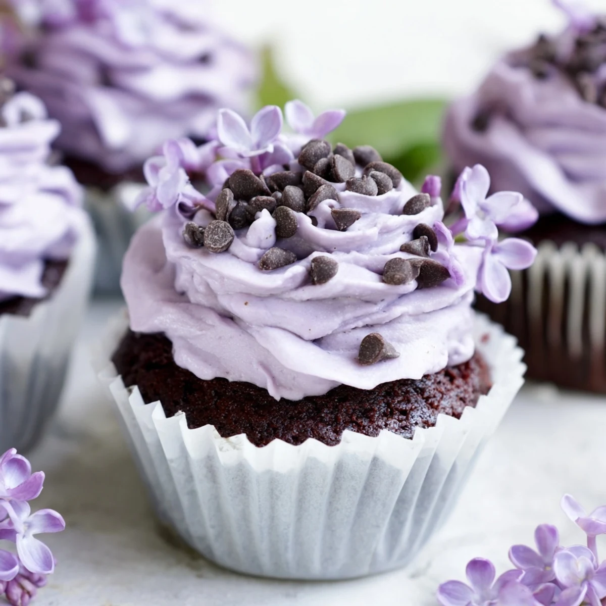 Small batch lilac chocolate cupcakes topped with fluffy floral buttercream and fresh purple blossoms