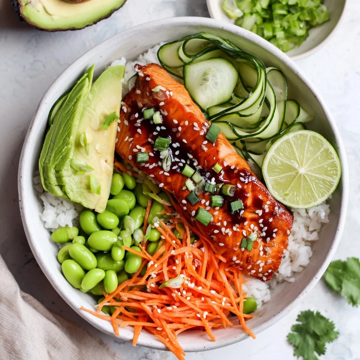 Close up of tender honey glazed salmon bowl served over rice with fresh toppings and zesty lime wedge