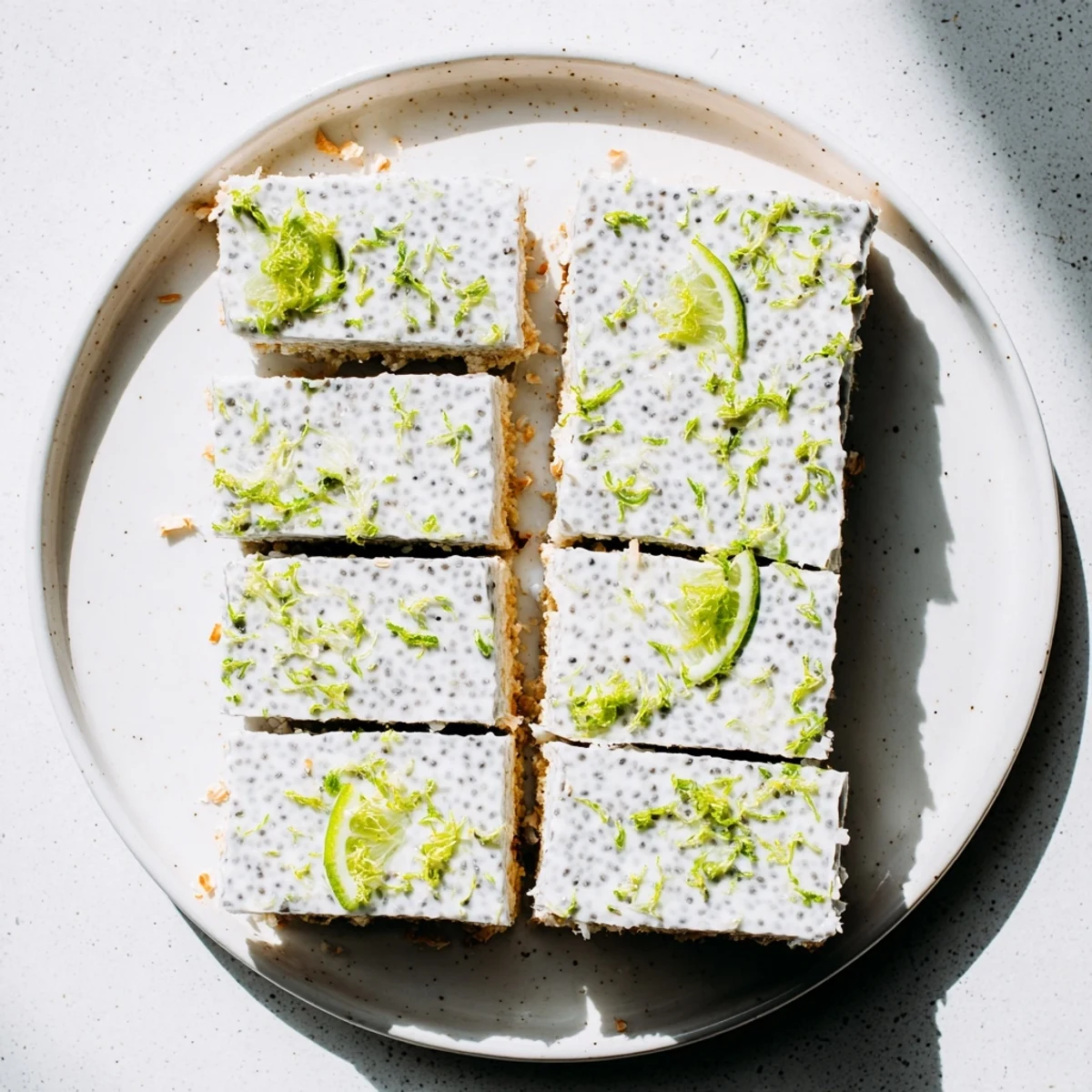 Creamy no bake coconut lime chia pudding bars cut into neat squares on white plate