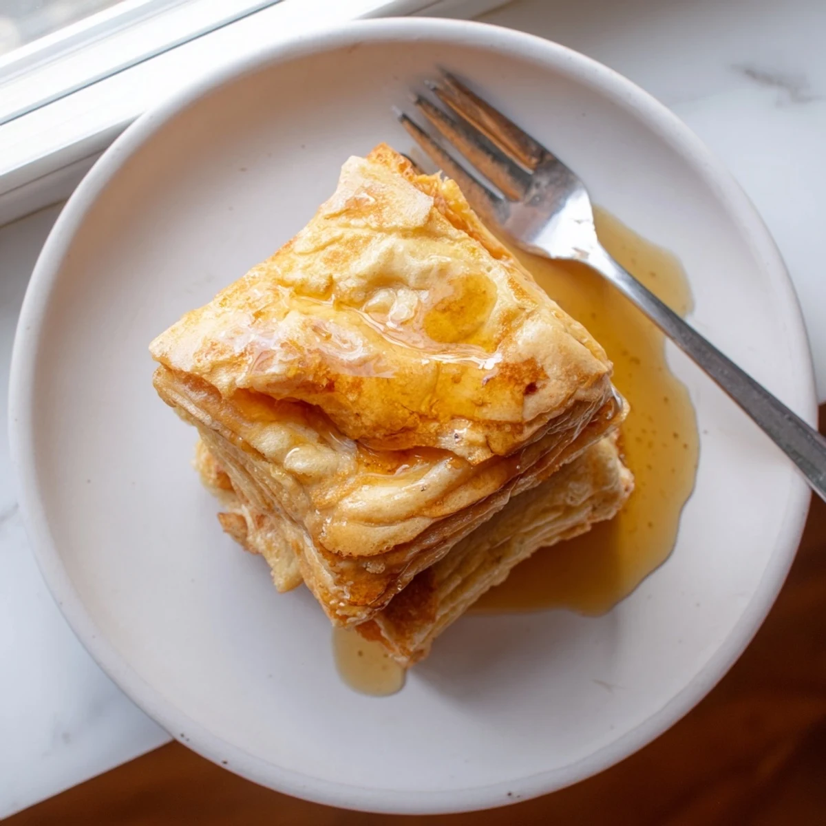 Handmade Meloui Moroccan pancakes arranged on a wooden board, ready to serve with jam and powdered sugar dusting
