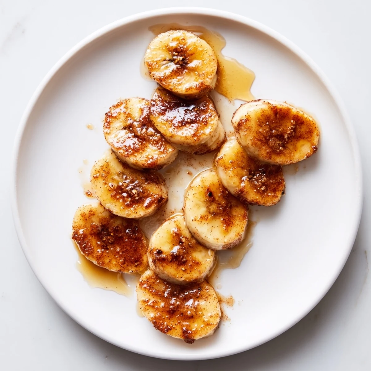 Golden pan fried cinnamon bananas sizzling in butter with brown sugar caramelized edges