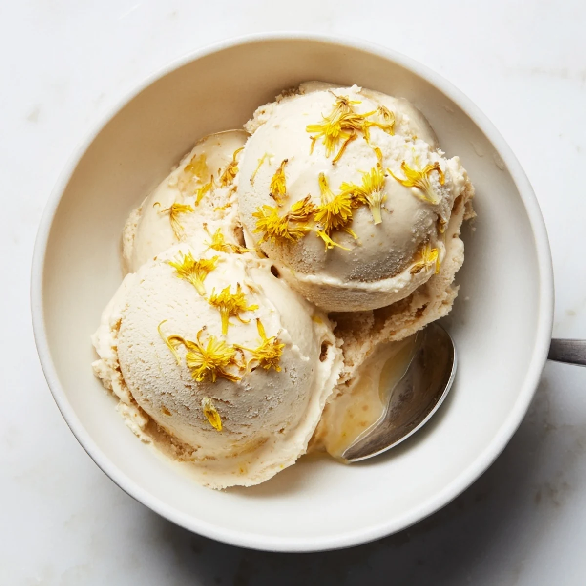 Rich homemade dandelion honey ice cream served in vintage glass bowl with honey swirl