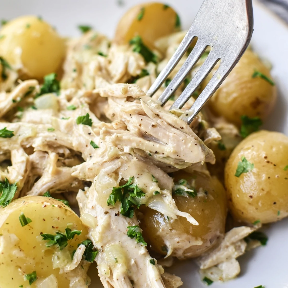 Comforting one-pot Slow Cooker Garlic Parmesan Chicken Potatoes served with fresh parsley garnish
