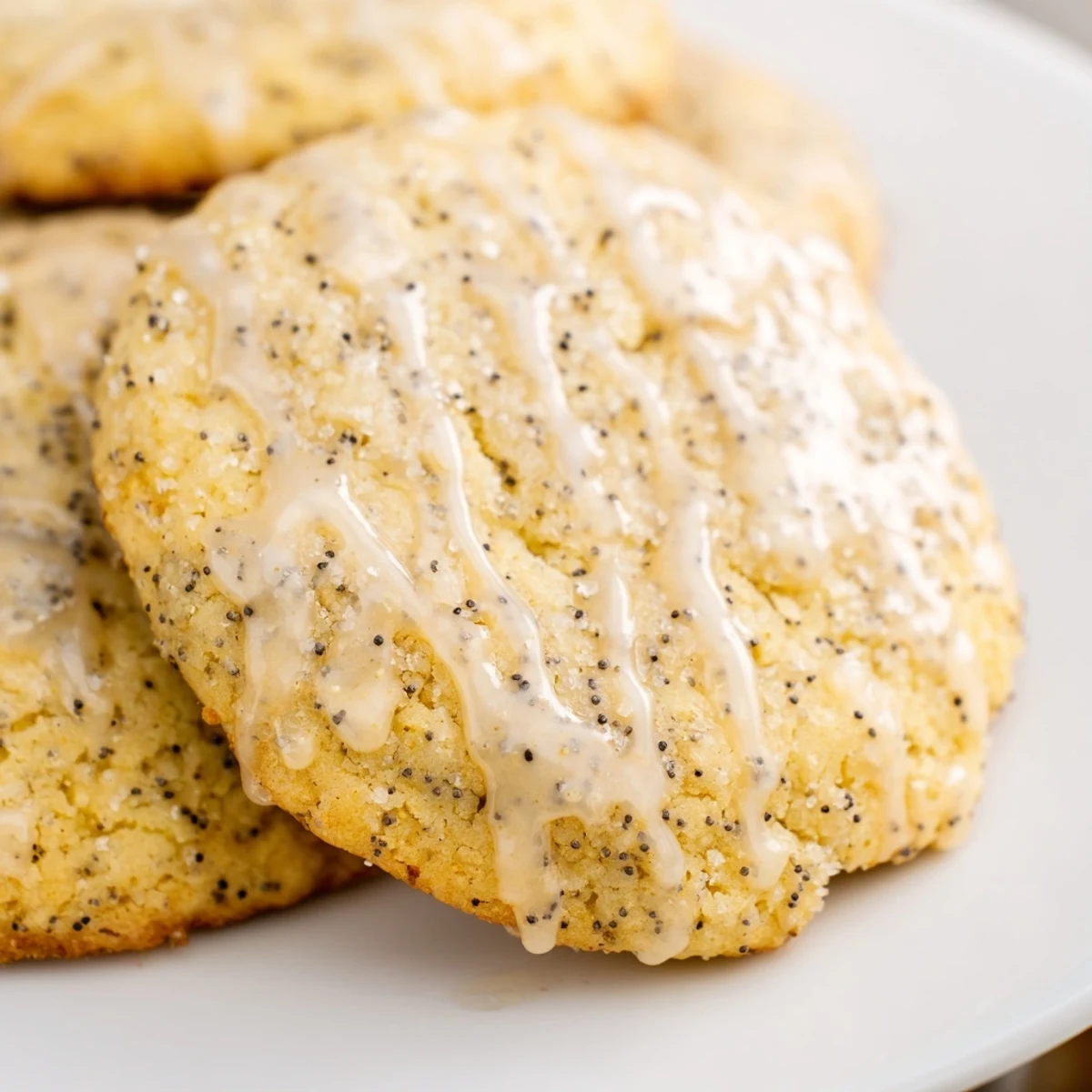 Chewy lemon poppy seed cookies speckled with tiny black seeds arranged on a cooling wire rack.
