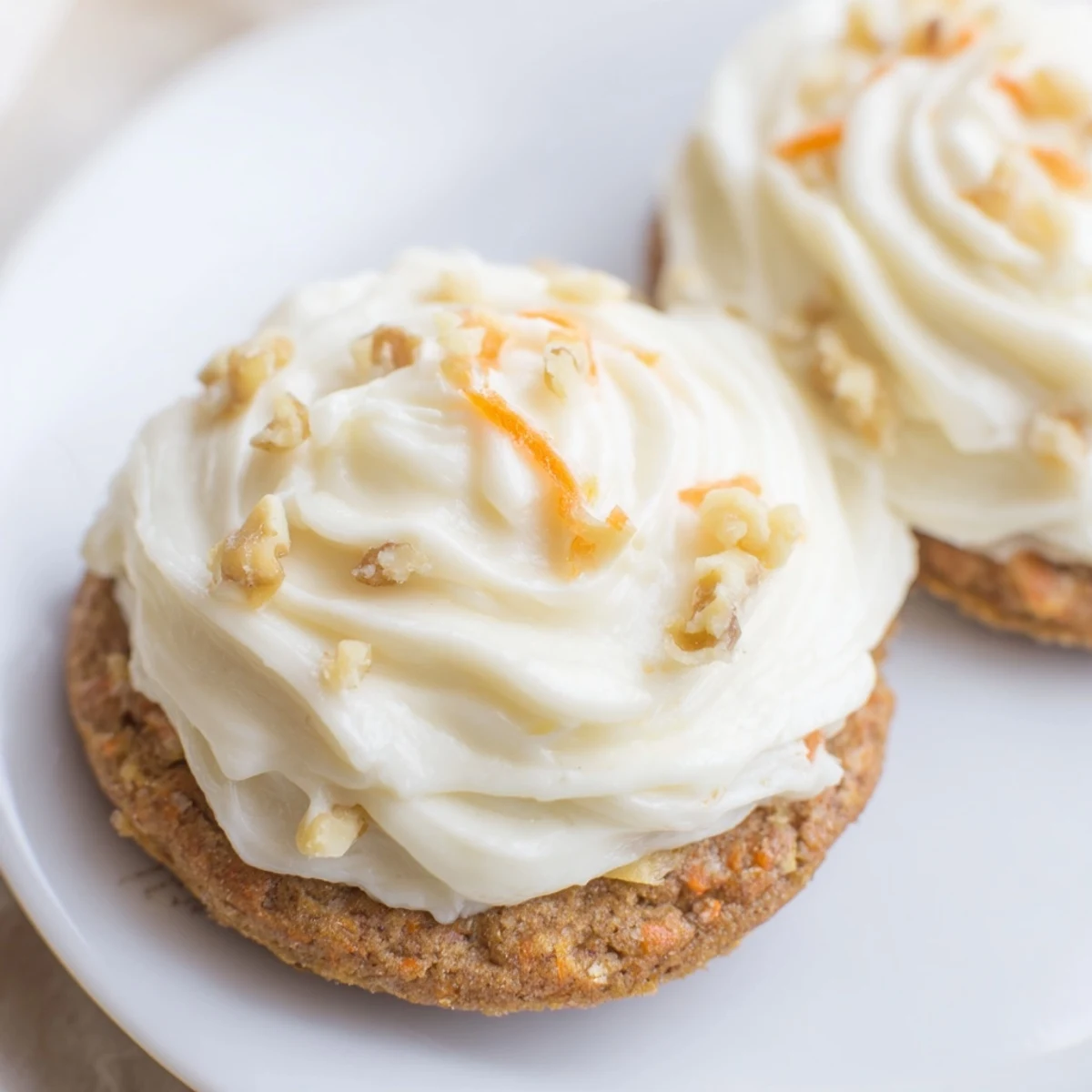Soft Crumbl carrot cake cookies with swirled cream cheese frosting on a rustic wooden board