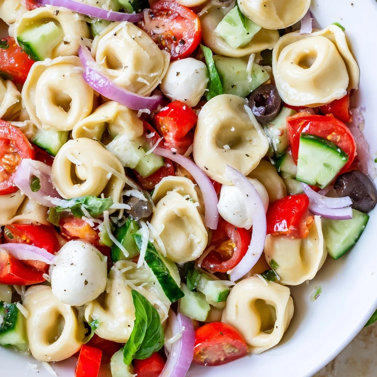 Colorful tortellini salad with cherry tomatoes, cucumber, and mozzarella in zesty Italian dressing