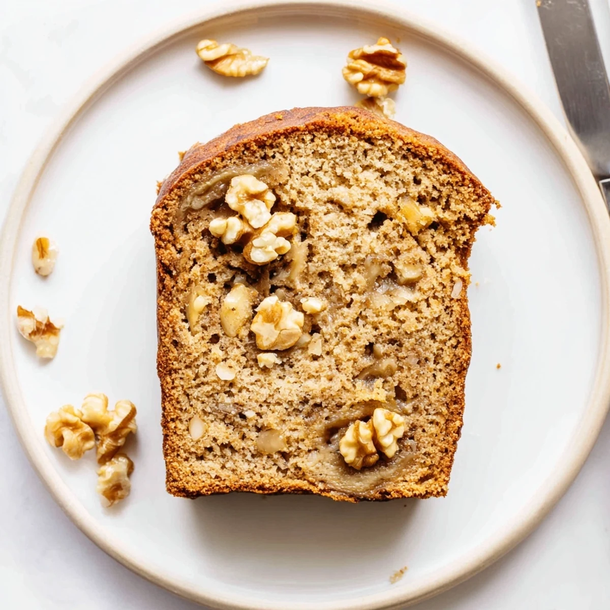 A thick slice of warm banana nut bread drizzled with melted butter