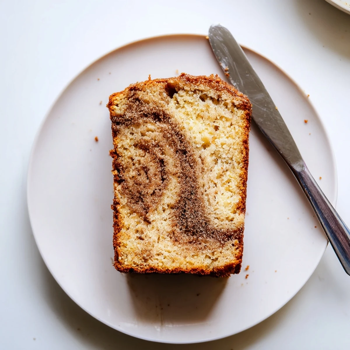 Moist snickerdoodle banana bread loaf topped with crackly cinnamon sugar