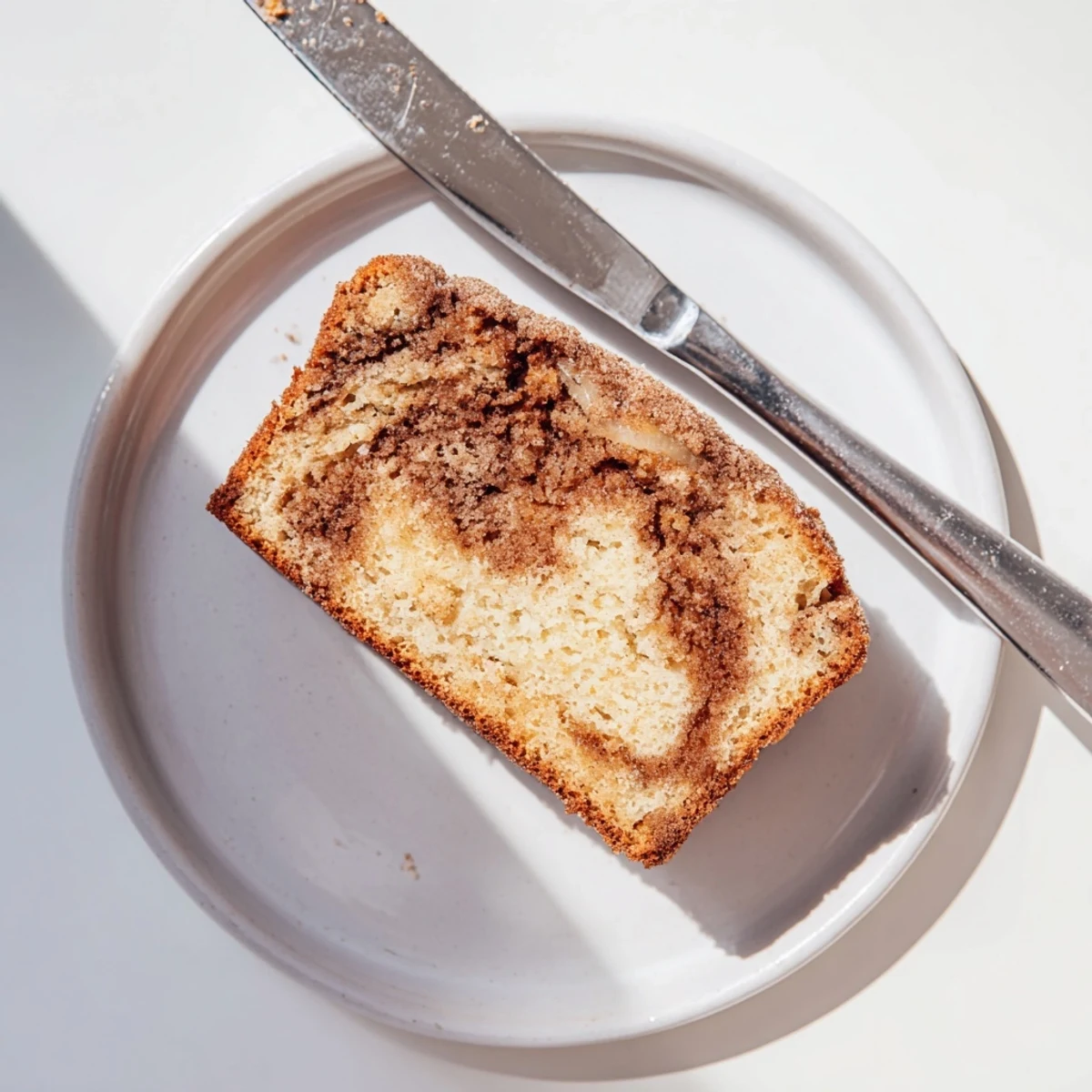 Thick slice of snickerdoodle banana bread served warm with melting butter