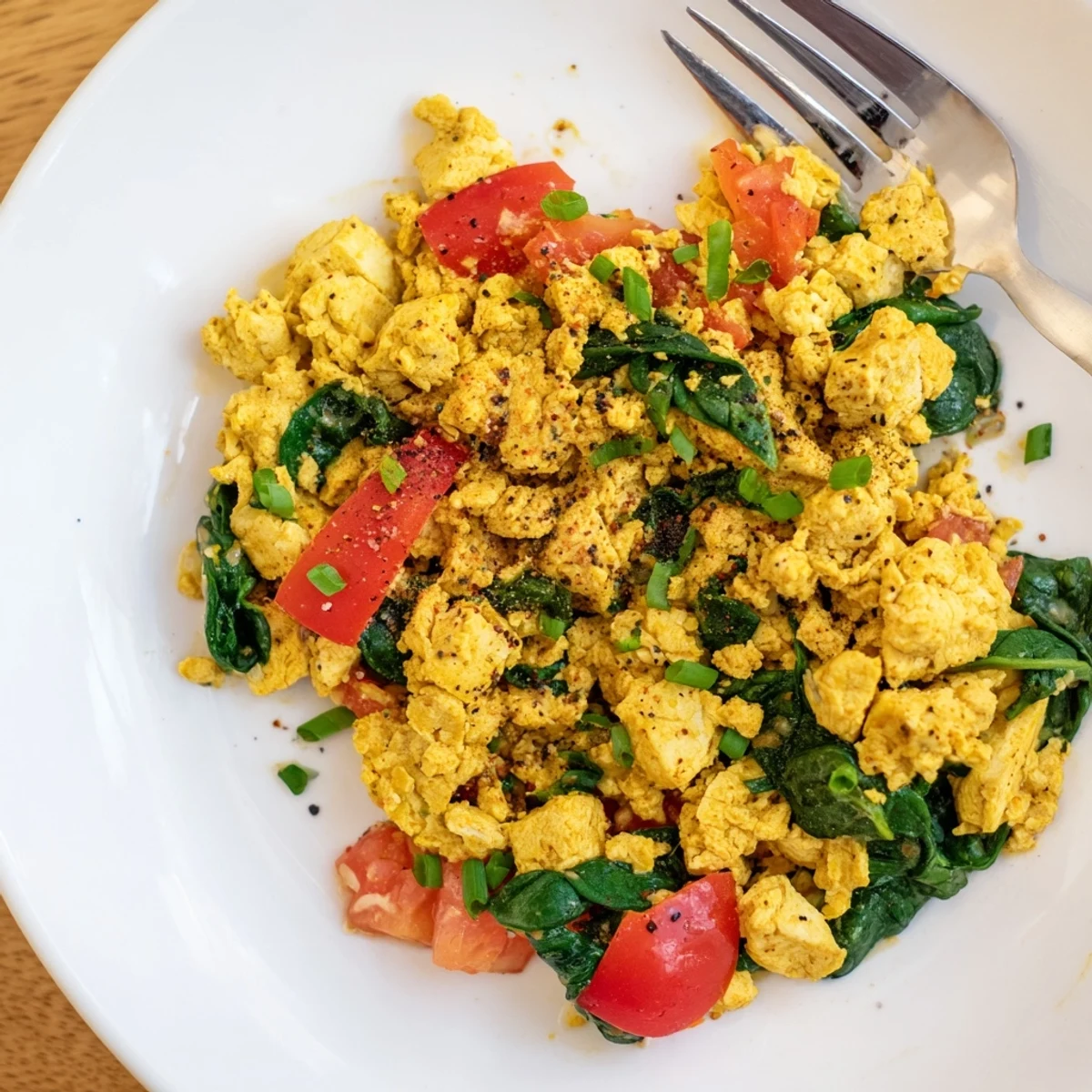 Creamy Tofu Scramble garnished with chives, served with avocado toast