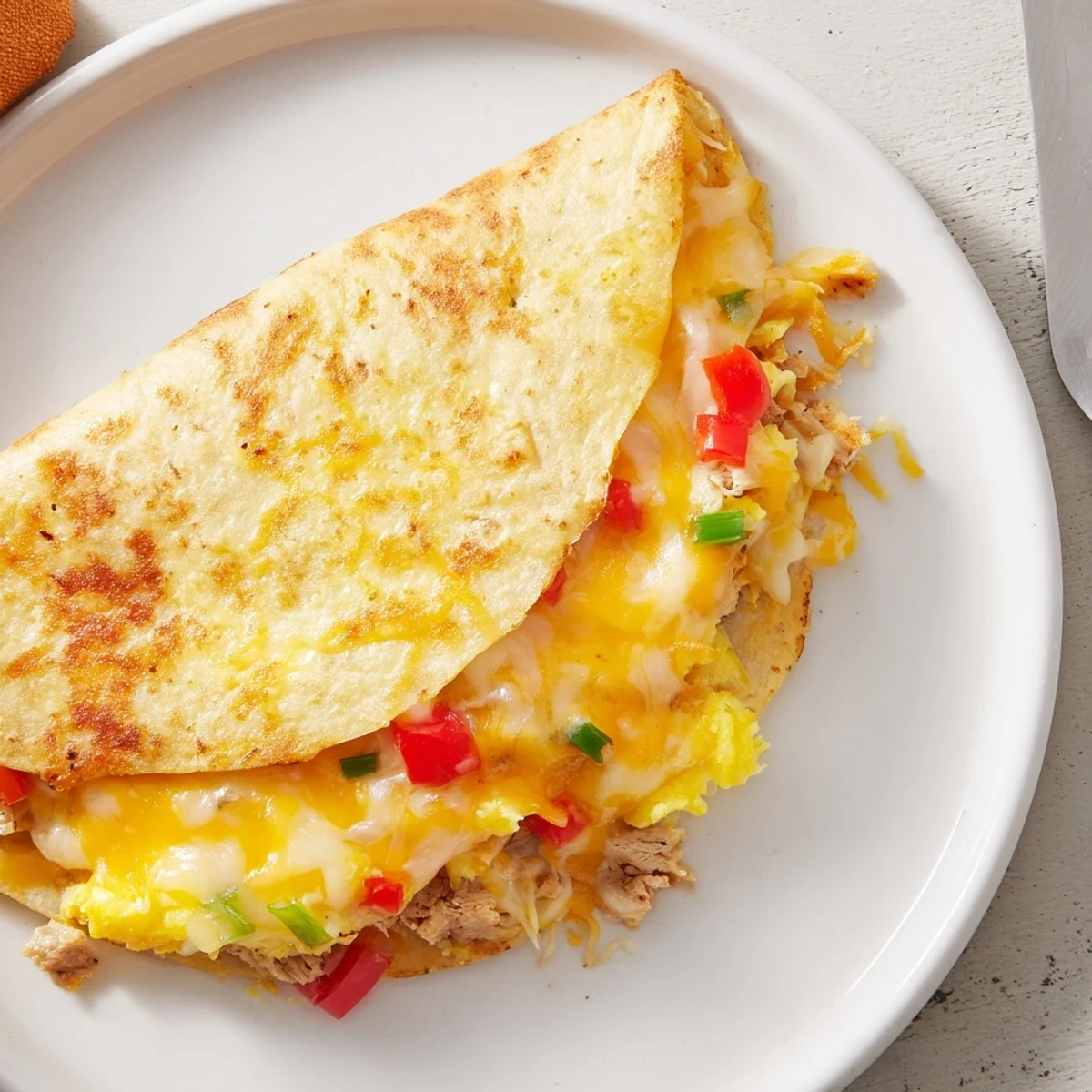 Pan-toasted Chicken Breakfast Quesadilla cut into wedges, served with avocado