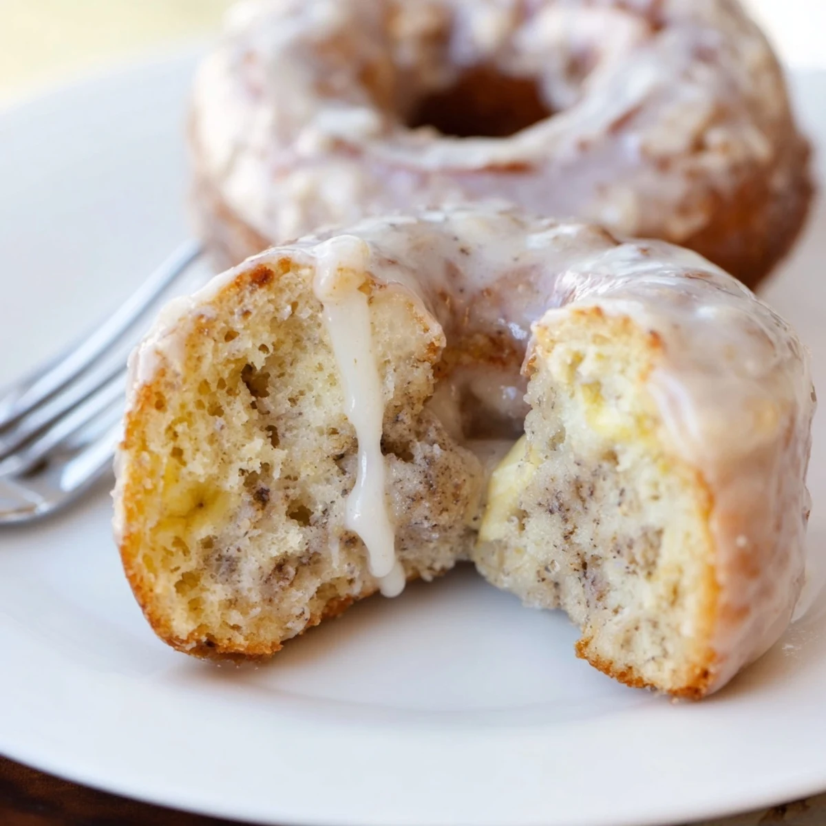 Banana Donuts glistening with vanilla glaze, golden edges and soft crumb
