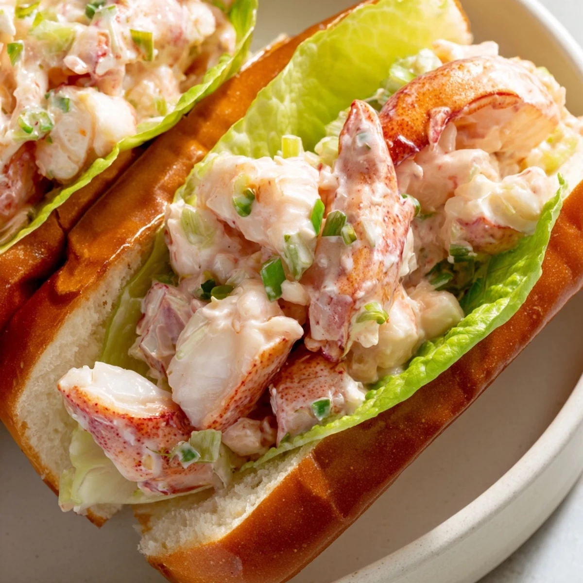 Golden buttery Maine style lobster rolls piled high with sweet tender meat in toasted split-top buns