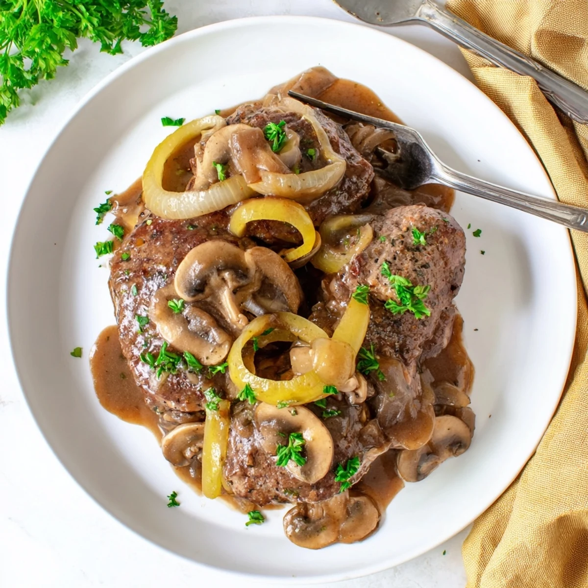 Golden brown country style smothered cube steak nestled in rich onion mushroom gravy