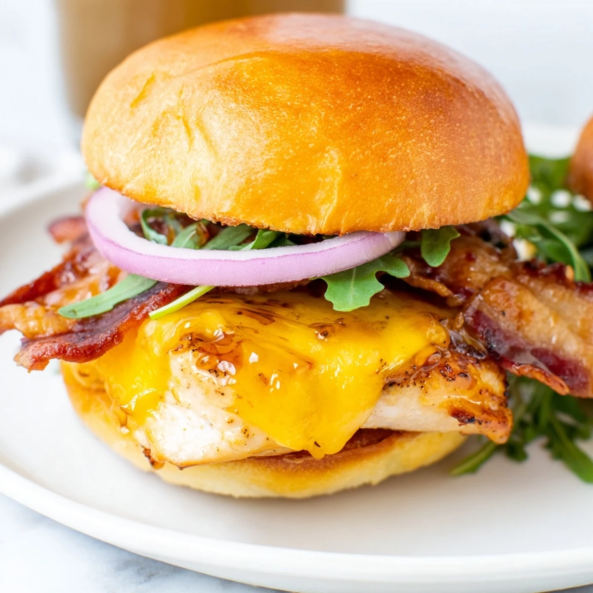 Crispy bacon and juicy maple glazed chicken sliders served on buttery buns with red onion