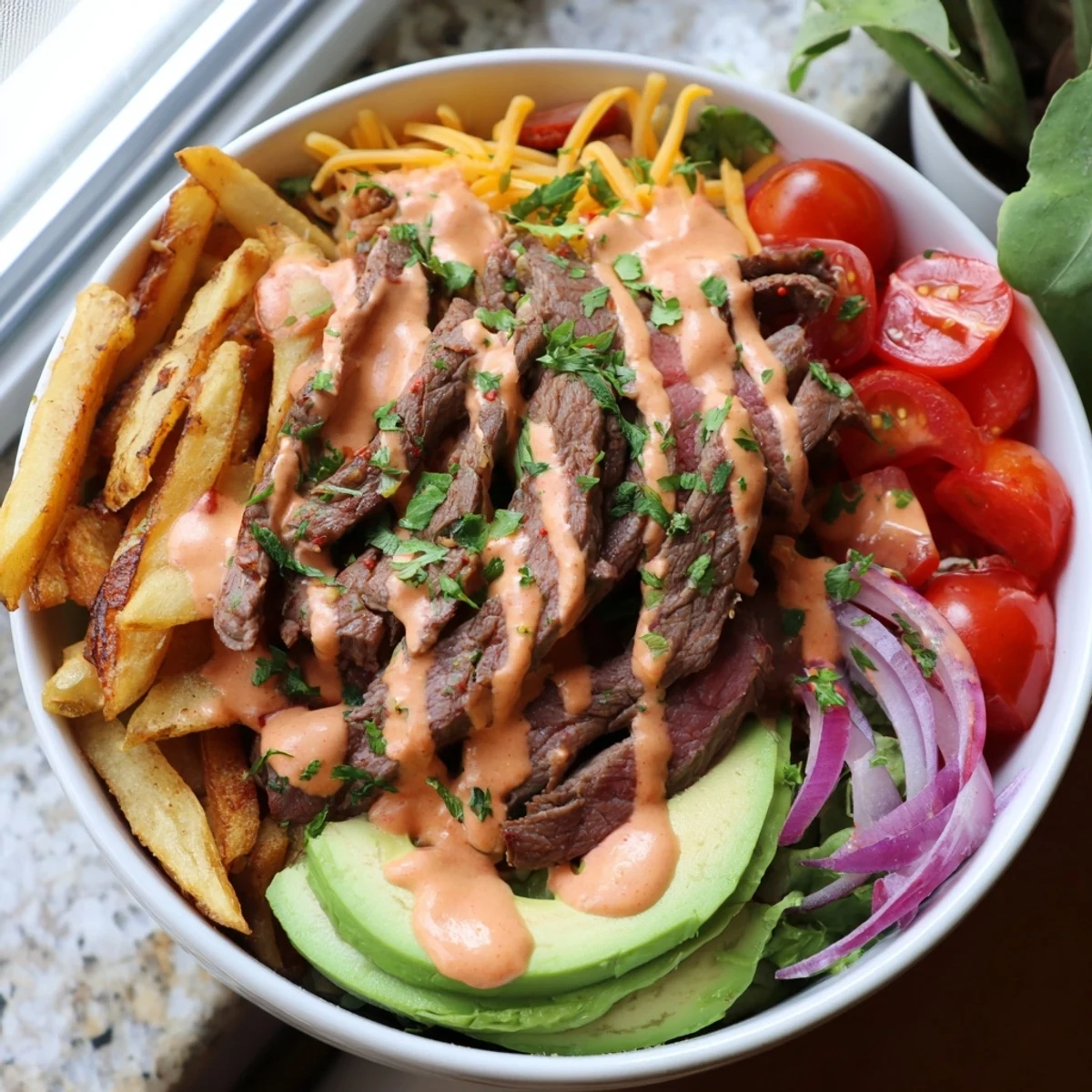 A loaded Steak Strips Crispy Fries Bowl drizzled with smoky sauce and melted cheddar cheese