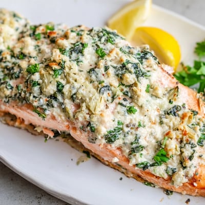 A close-up of creamy spinach and artichoke stuffed salmon, showcasing the luscious, cheesy filling peeking out from the flaky fish.