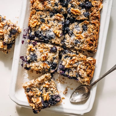 Warm serving of Lemon Blueberry Baked Oatmeal with juicy berries and oats bubbling gently