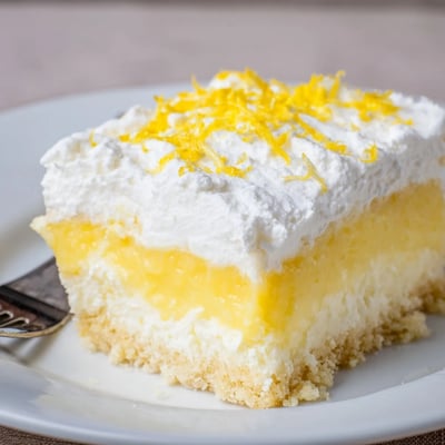 Chilled Lemon Lush Cake on a dish, crisp crust and bright zest